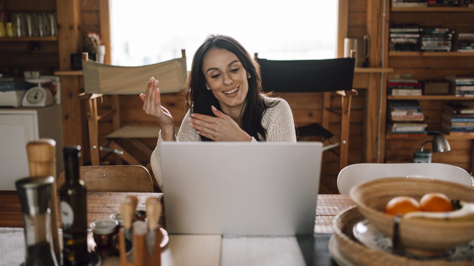 A woman smiling during a video call lesson on her laptop