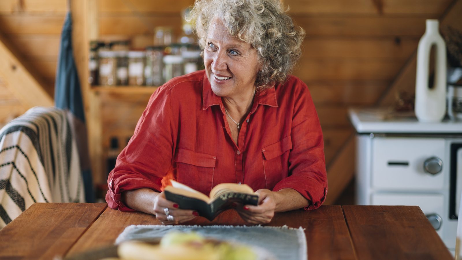 A woman reading a book aloud at a table