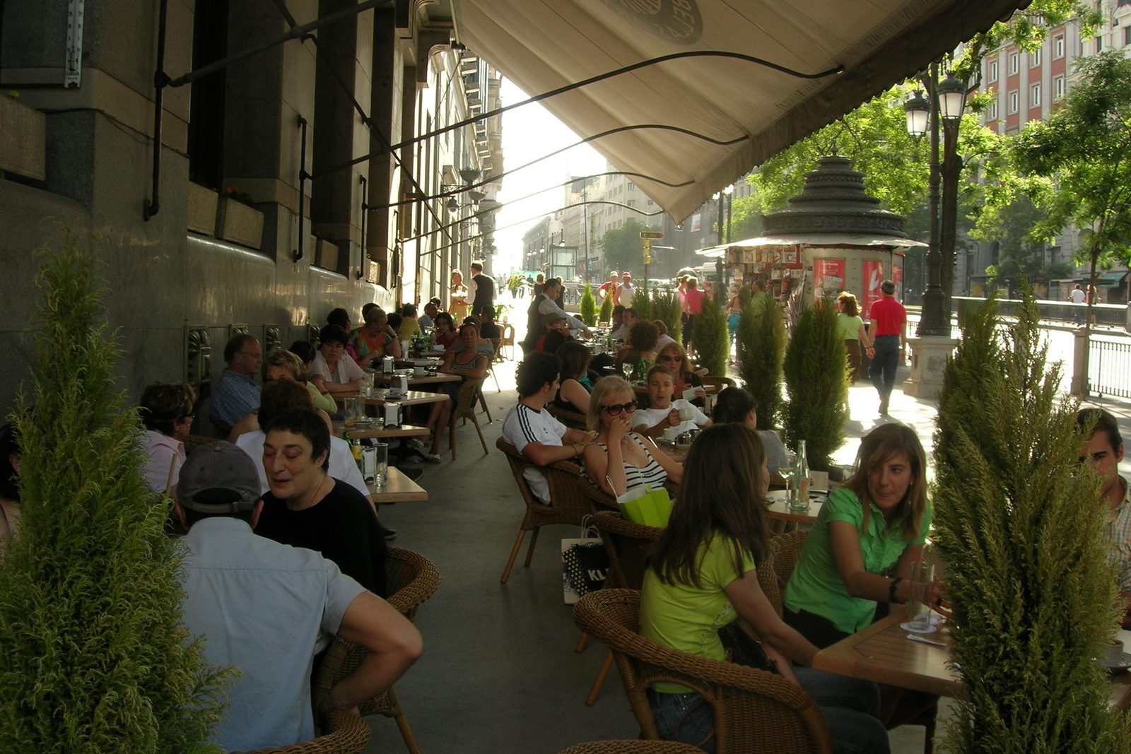 Outdoor cafe terrace in Madrid with people at tables