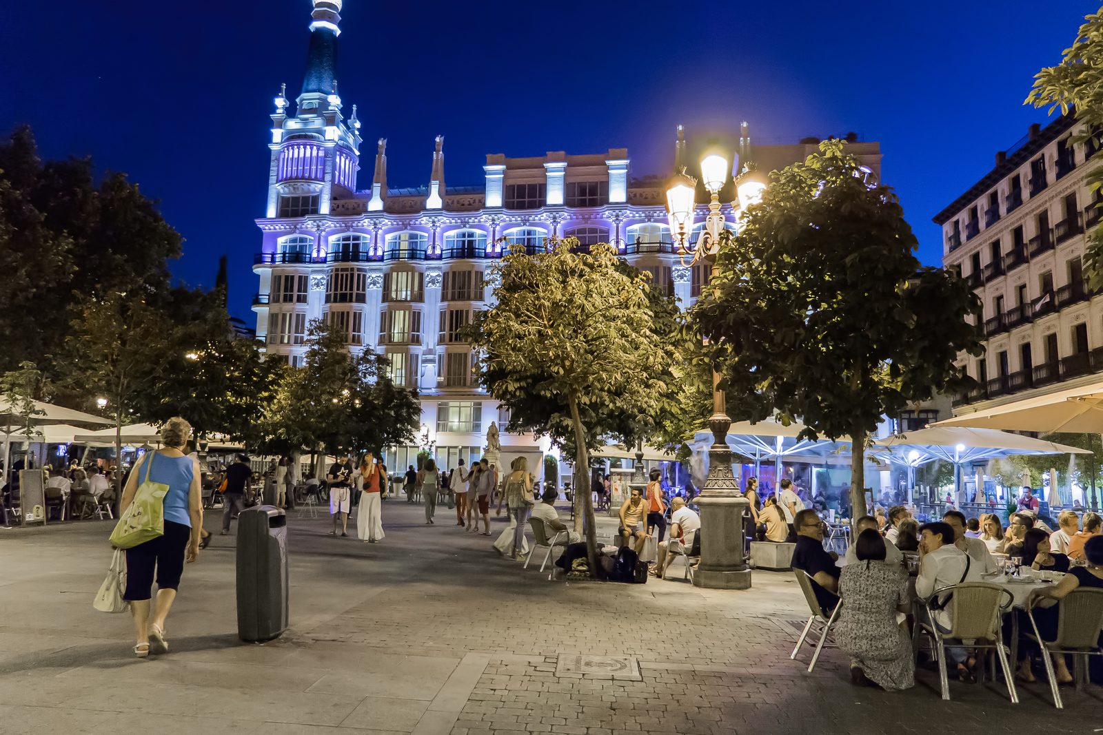 Plaza de Santa Ana in Madrid lit up at night with people