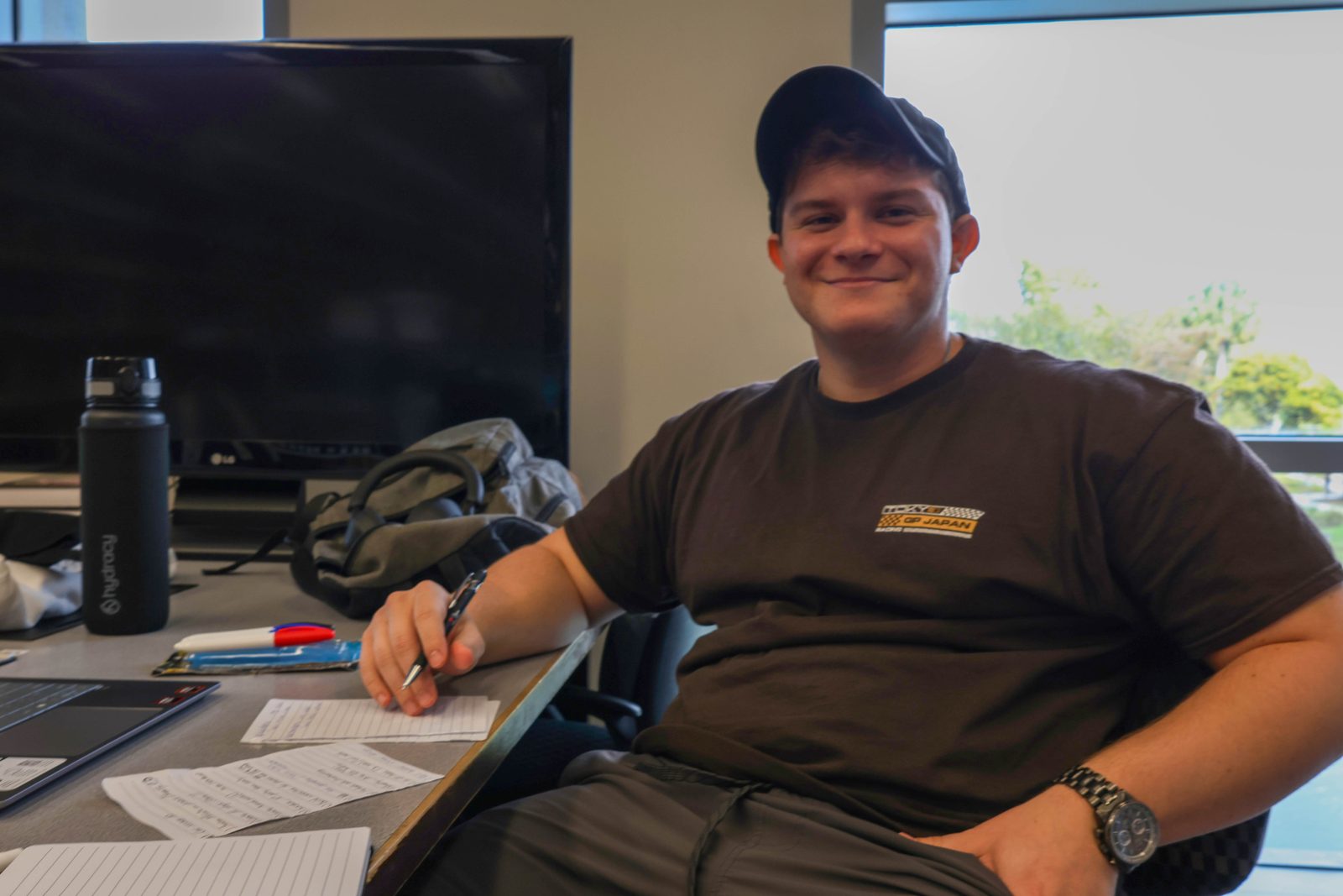 A smiling student working on assignments at a desk