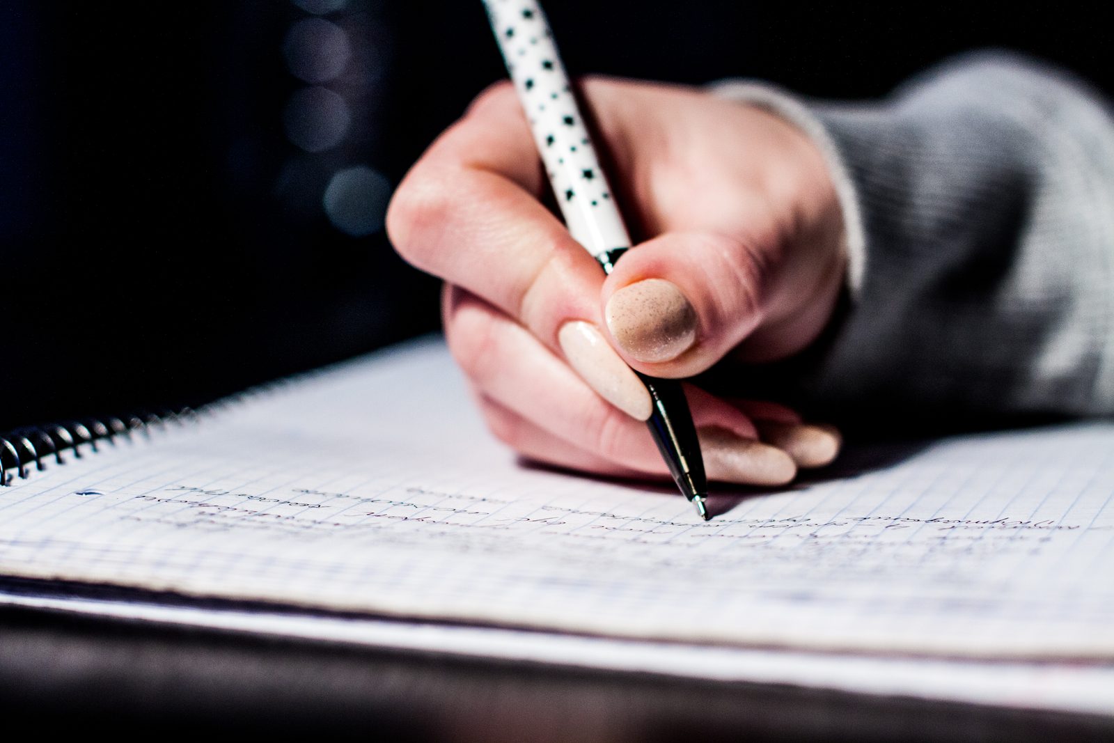 A hand writing notes in a notebook